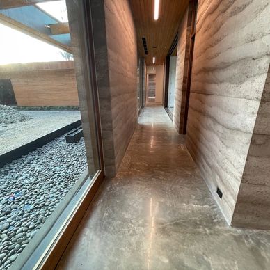 polished concrete floors in a modern home with rammed earth walls