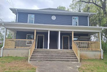 Blue two-story duplex with front porch and stairs.