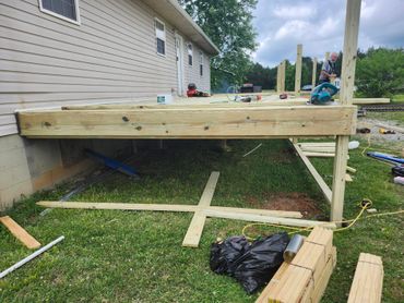 Construction of a wooden deck attached to a house in progress.