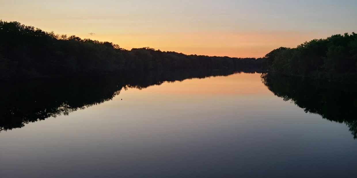 Calm river reflecting the sunset sky.