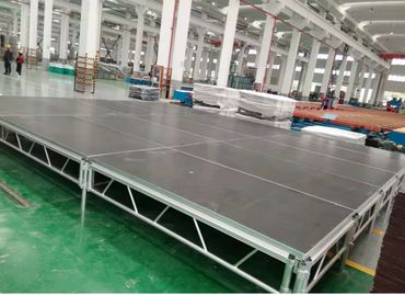 Large industrial stage platform inside a spacious factory.