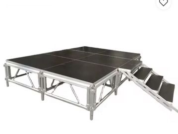 Modular stage platform with stairs, made of metal and black panels.