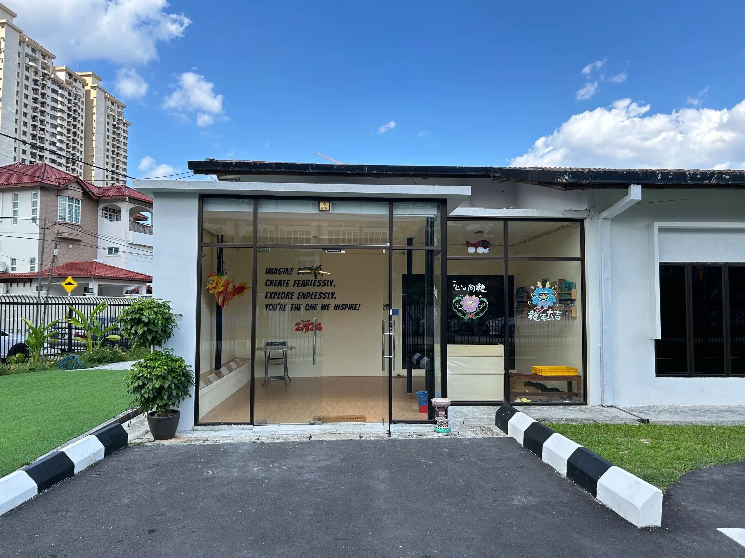 Modern building entrance with glass doors and motivational text on the wall.