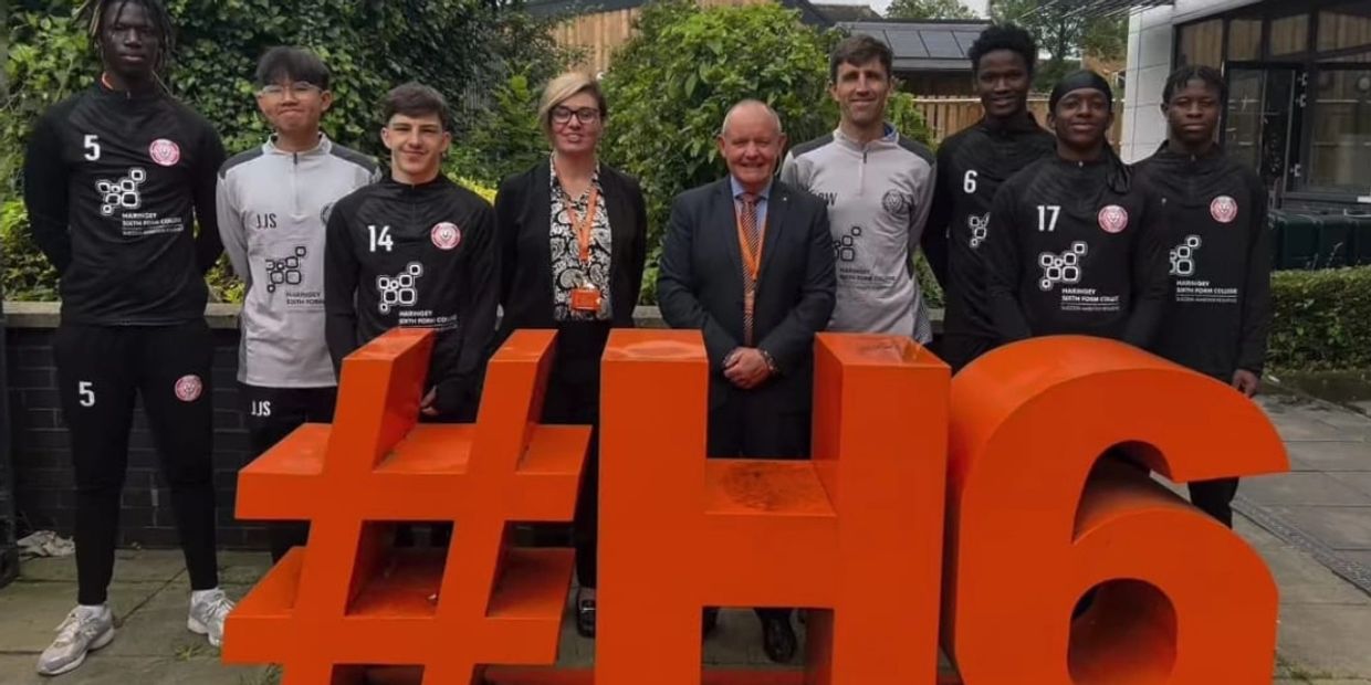 Group of people posing behind a large orange hashtag and number 46.