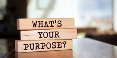 Wooden blocks spelling out 'WHAT'S YOUR PURPOSE?' on a table.