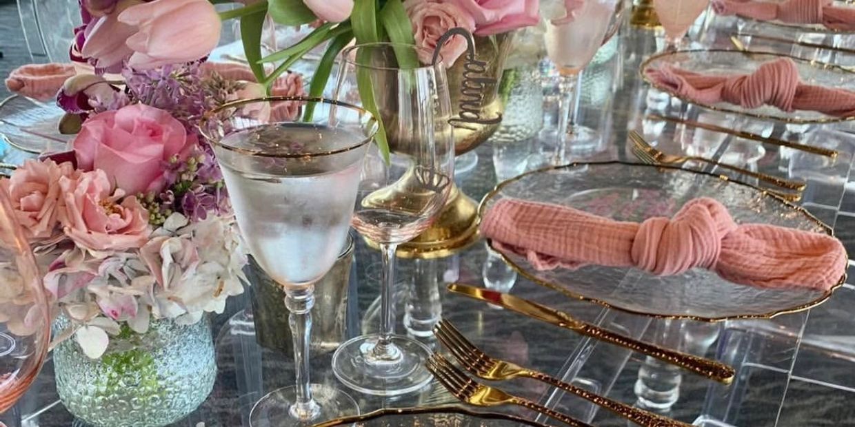 Elegant table setting with pink roses and gold cutlery.
