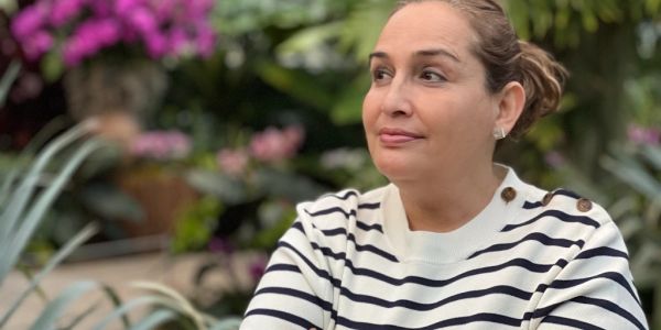 Woman in a striped sweater outdoors, looking sideways.