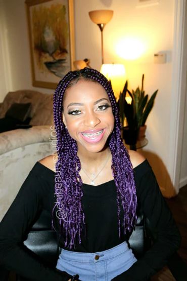 A girl with purple braids and makeup for her graduation