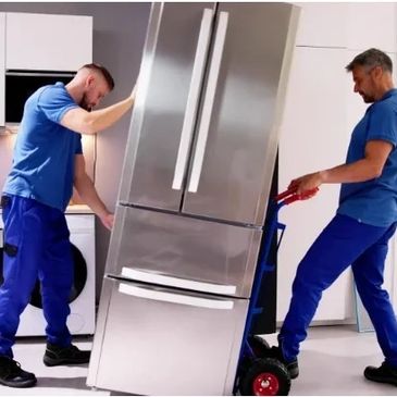 Two movers carrying a large fridge on a dolly in a kitchen.