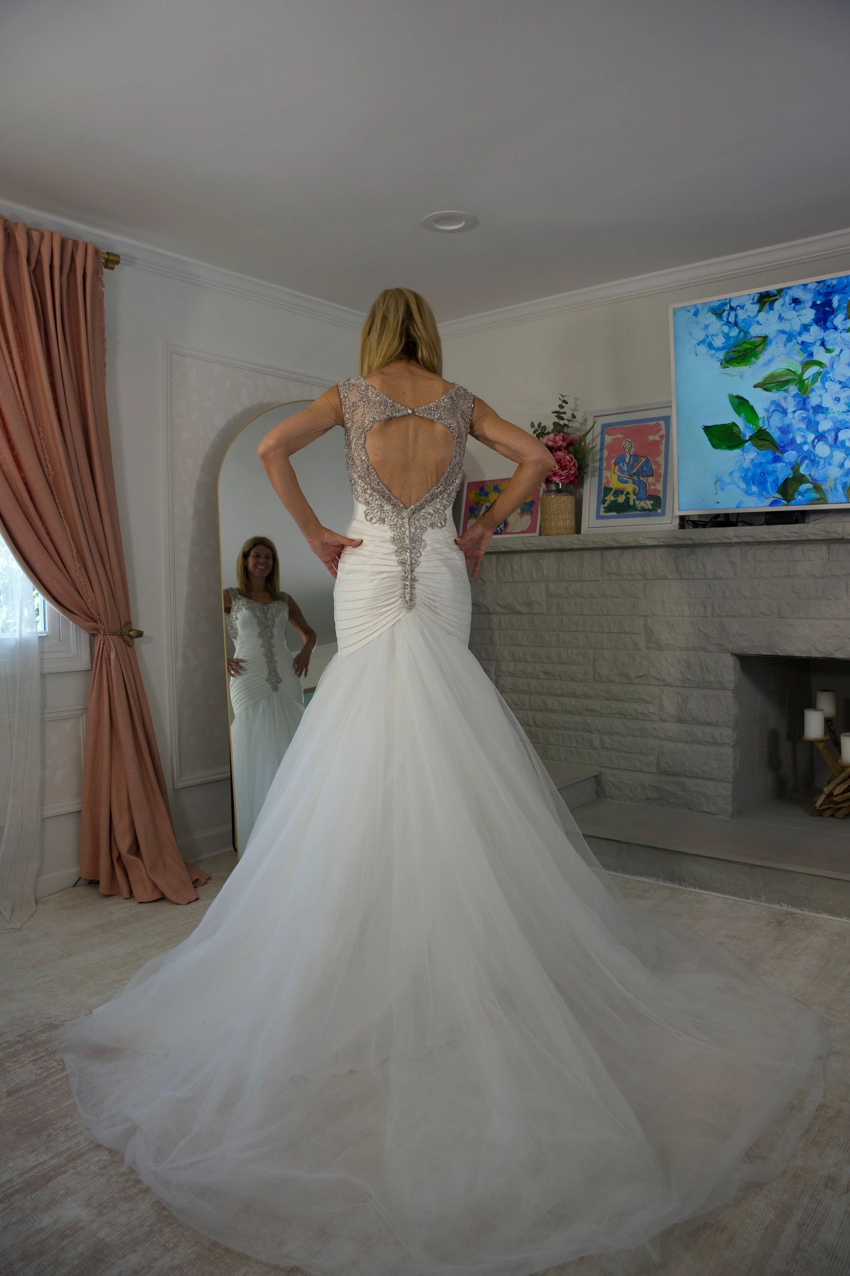 Woman trying on a wedding dress in front of a mirror.