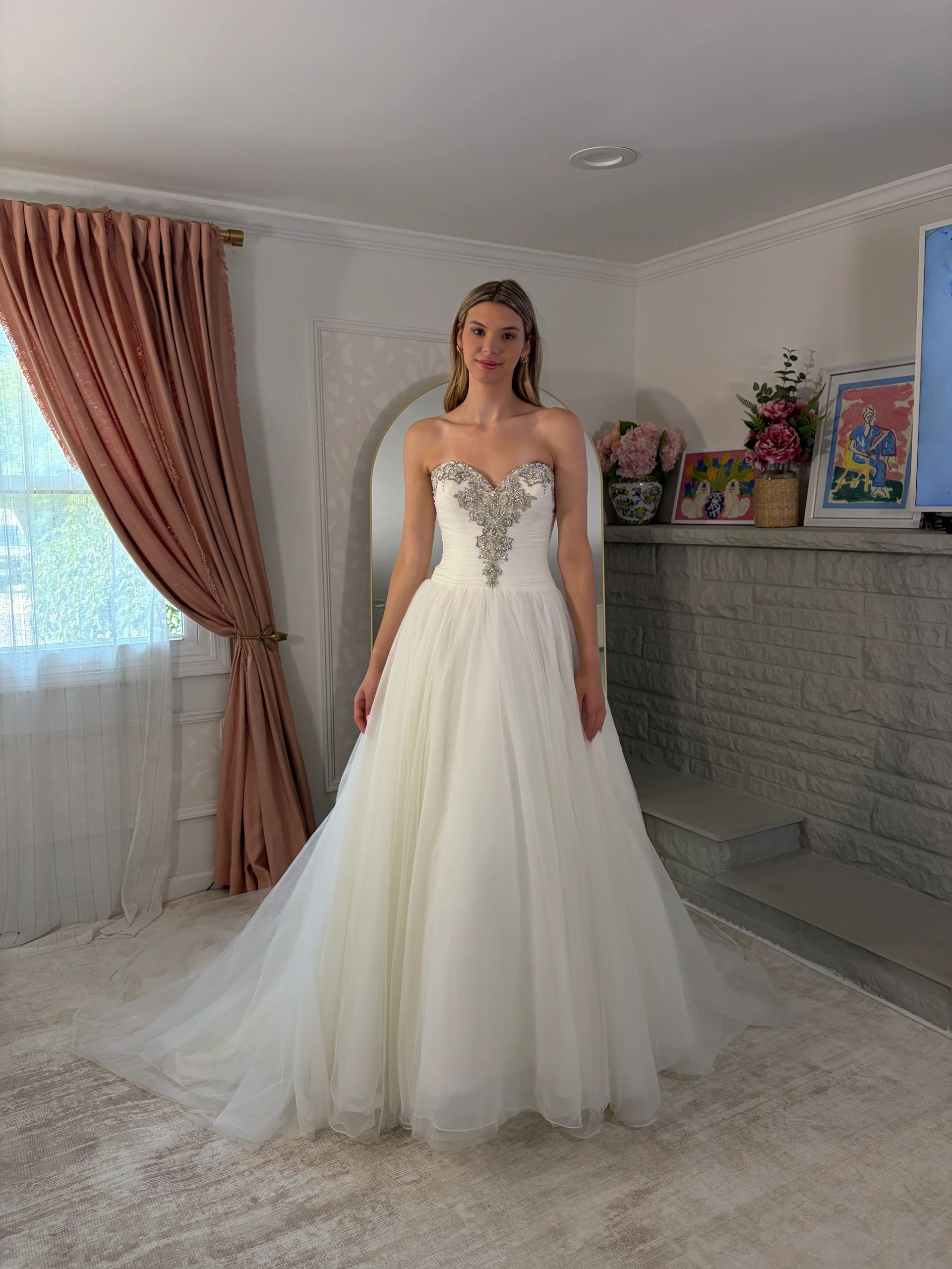 Woman in elegant white strapless ball gown with beaded bodice.