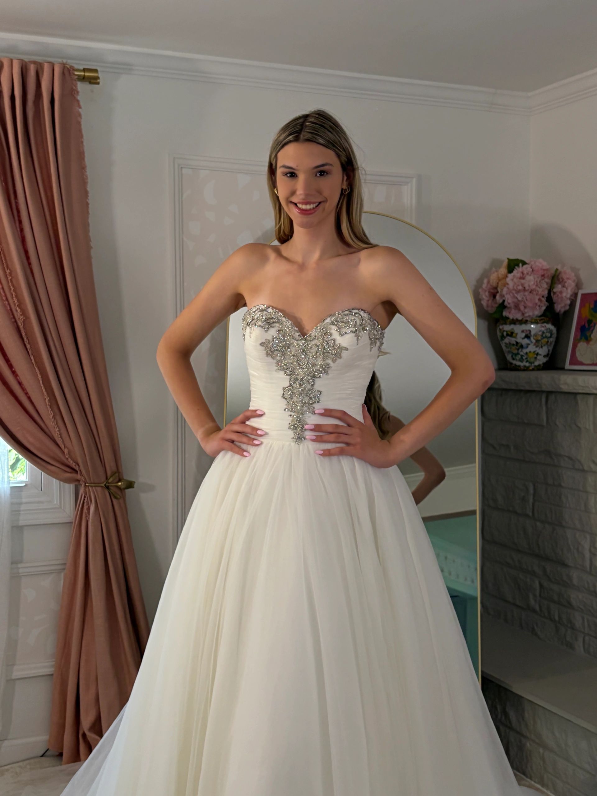 Bride wearing a strapless white gown with silver embroidery.