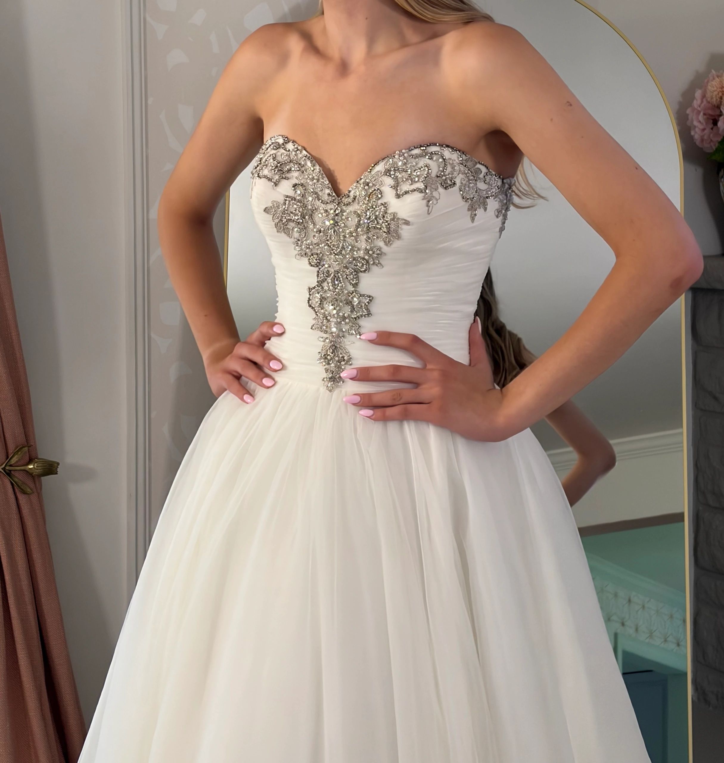 Strapless white wedding dress with intricate silver embroidery.