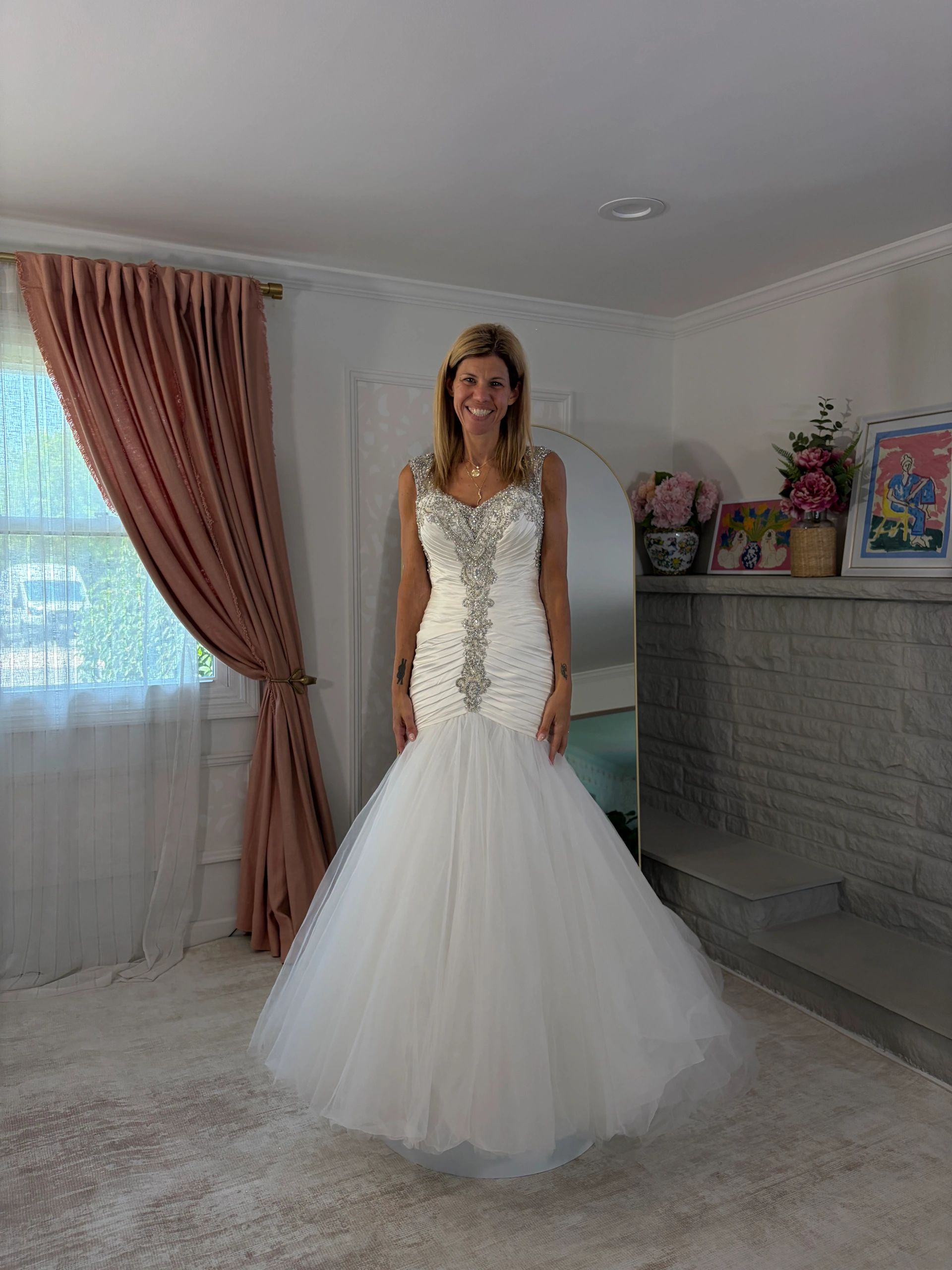 Woman in a white wedding dress standing indoors.