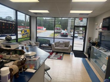 Waiting area of an auto repair shop with couch and informational signs.