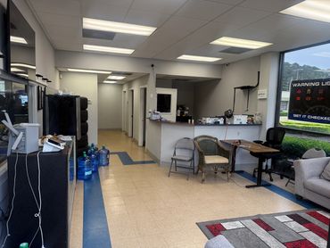 Reception area with chairs, water bottles, and a warning light poster on the window.