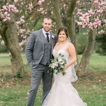 Bride and Groom in front of a Magnolia tree. She is holding her bridal bouquet. London Ontario 