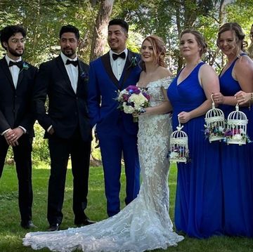 Bride & Groom standing in the center with the bridal party. Girls holding birdcages with arrangement