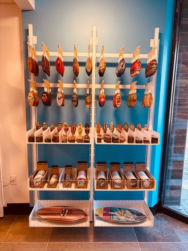 Display of colorful Hawaiian-themed coasters and souvenirs on shelves.