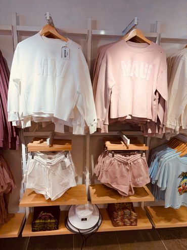 Casual Maui-themed sweatshirts and shorts displayed in a store.