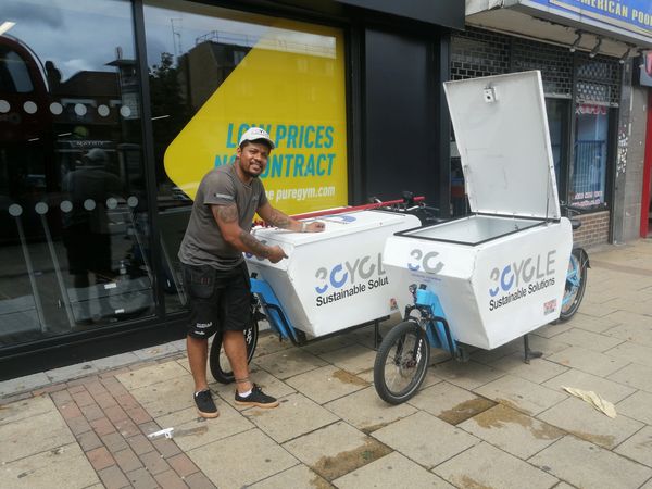 Man standing next to two cargo bikes with '3Cycle Sustainable Solutions' logos.