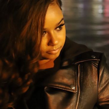 Woman in a leather jacket looking to the side.