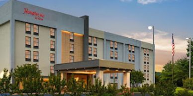 Exterior of a Homewood Suites by Hilton hotel at sunset.