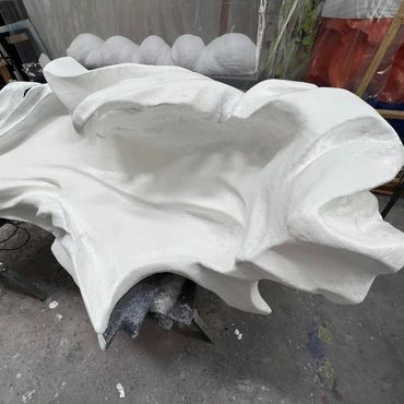 Curling waveform sculptured and plastered in white smooth flowing forms, by David Kujda