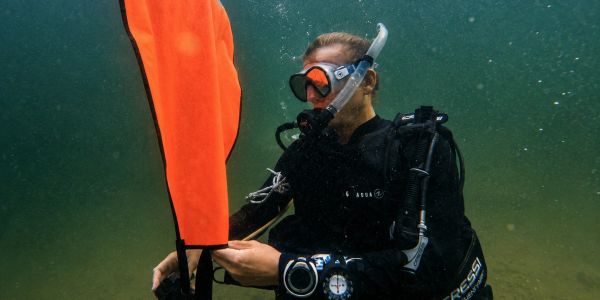 Scuba diver underwater using a lift bag during a rescue class