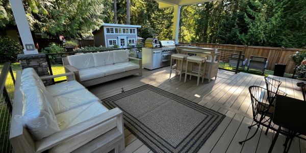 Covered patio with white seating and BBQ and bar area.