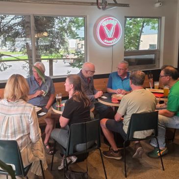 Group of people socializing at a bar table.