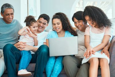 Multigenerational family enjoying time together looking at a laptop.