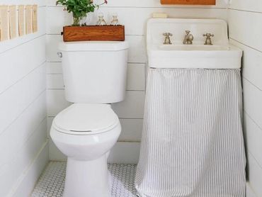 white bathroom with sink, toilet and two mirrors