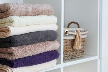 folded towels and basket in a closet