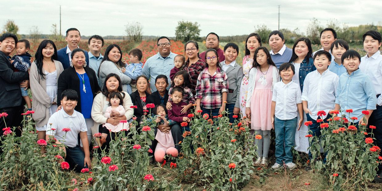 Large family posing in a flower field.