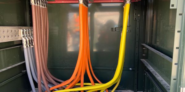 Color-coded electrical cables inside a metal panel.