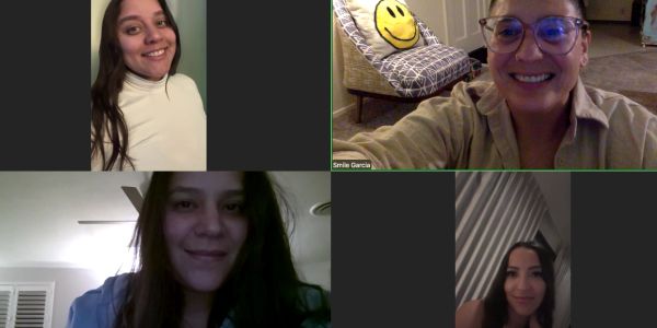 Four women on a video call, smiling.