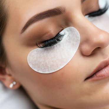 Close-up of a woman with eyelash extensions and under-eye pad.