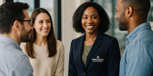 Four colleagues smiling and conversing in a modern office setting.