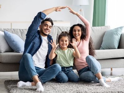 Family care. Arab parents make symbolic roof of hands over cute daughter