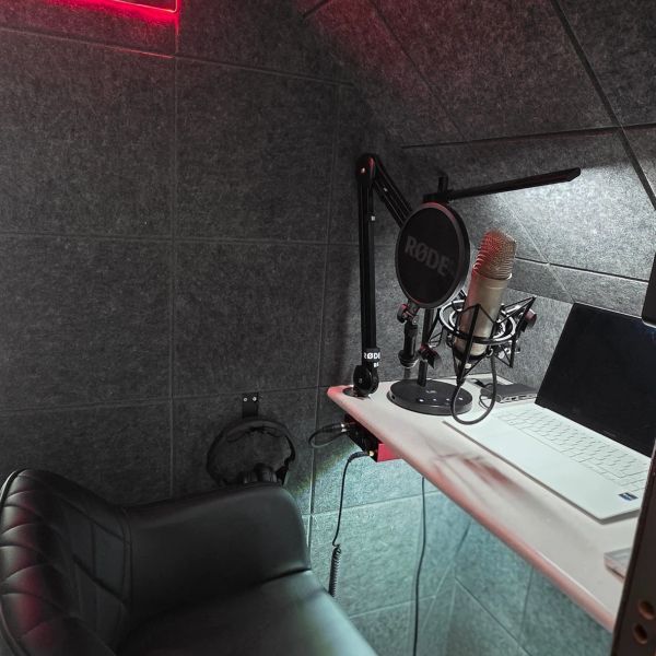 Cozy podcast or recording studio setup with 'ON AIR' neon sign.
