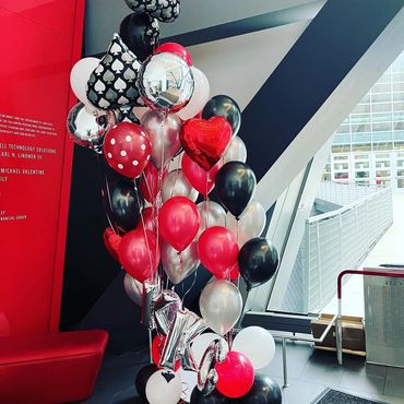A picture of red , black and silver color bunch of balloons