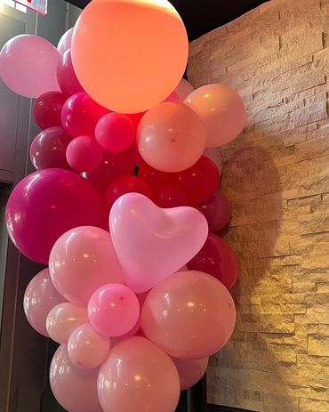 A bunch of balloons in orange pink and red color