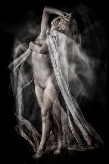 Ethereal nude figure draped in flowing fabric with motion blur effect.