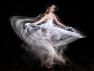 Ballerina twirling gracefully, captured with motion blur.