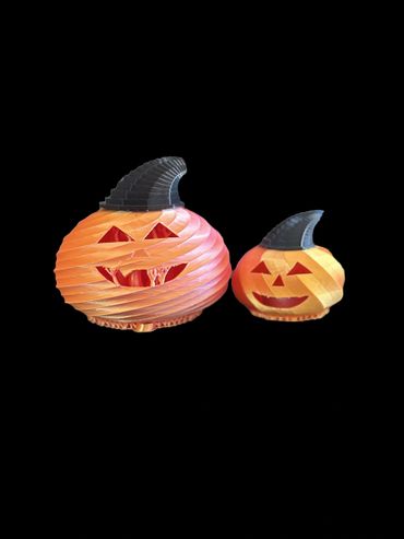 Two 3D-printed Halloween pumpkins with black witch hats.