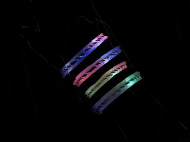 Colorful glowing bracelets on a dark background.