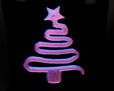 Glowing pink and blue Christmas tree ornament with a star on top.