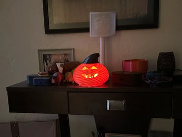 Glowing Halloween pumpkin decoration on a dark wooden table.