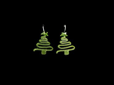 Green Christmas tree-shaped earrings on a black background.